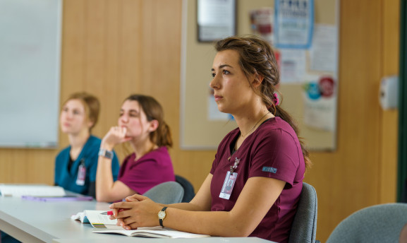 CNA student in the classroom listening to the instructor