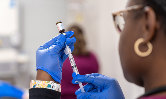 Nursing student using a syringe to draw medicine from a vile.