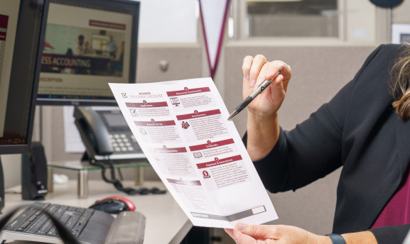 Cost of attendance being explained to a student on a sheet of paper.