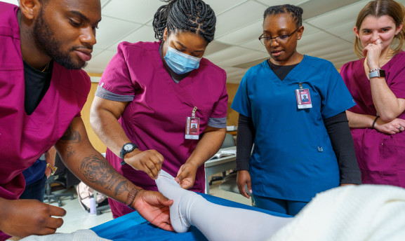CNA students changing socks on a manikin 