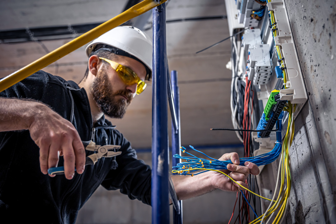 Student working on an electronic switchboard with pliers